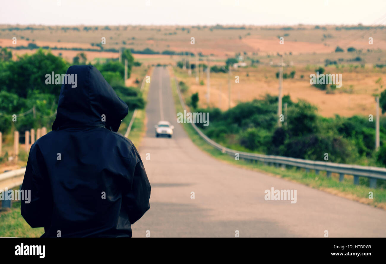 Homme debout asiatique sur le chemin et attendons avec intérêt de face avec son choix, droit à l'Autoroute, Campagne du Vietnam l'usure des hommes veste noire à illustr Banque D'Images