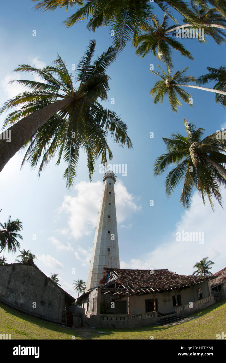 Phare blanc debout sur une île avec des palmiers à Belitung dans la journée avec pas de gens autour. Banque D'Images