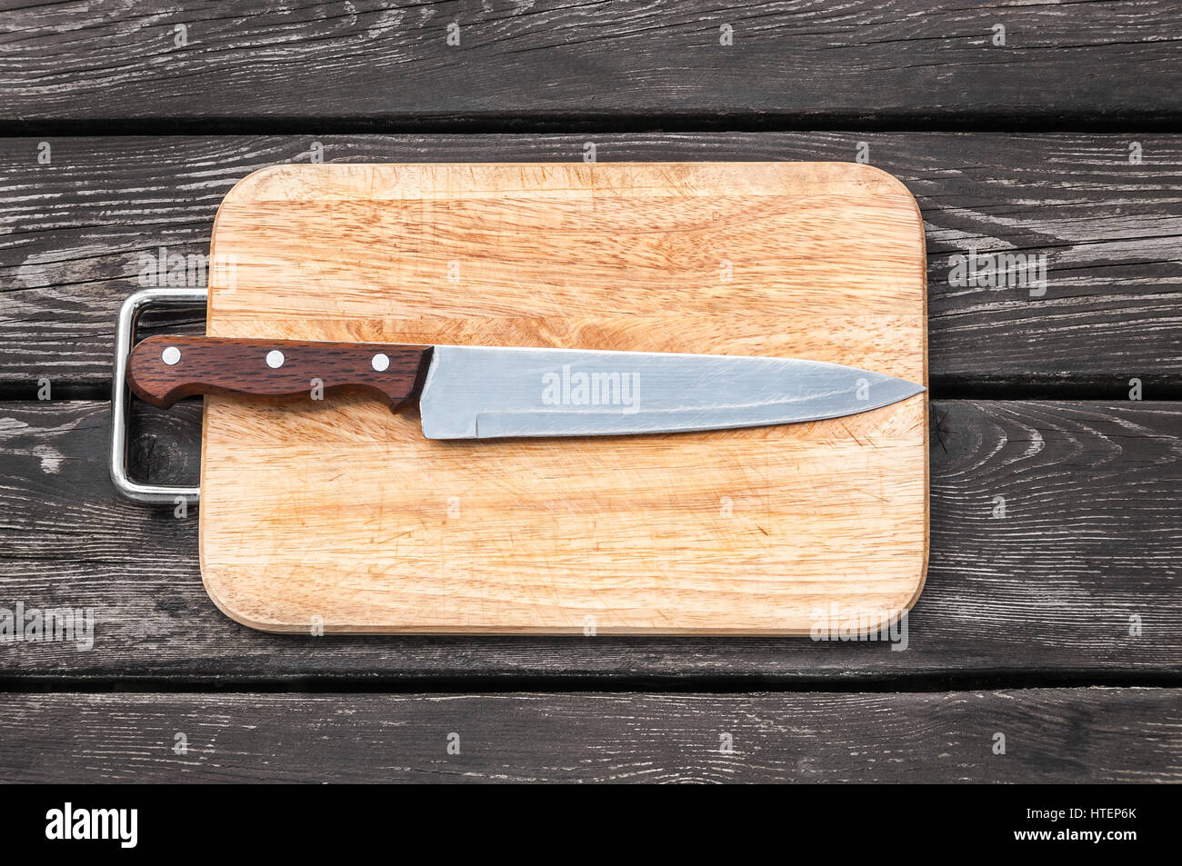Couteau en acier sur une planche à découper sur fond de bois avec Banque D'Images