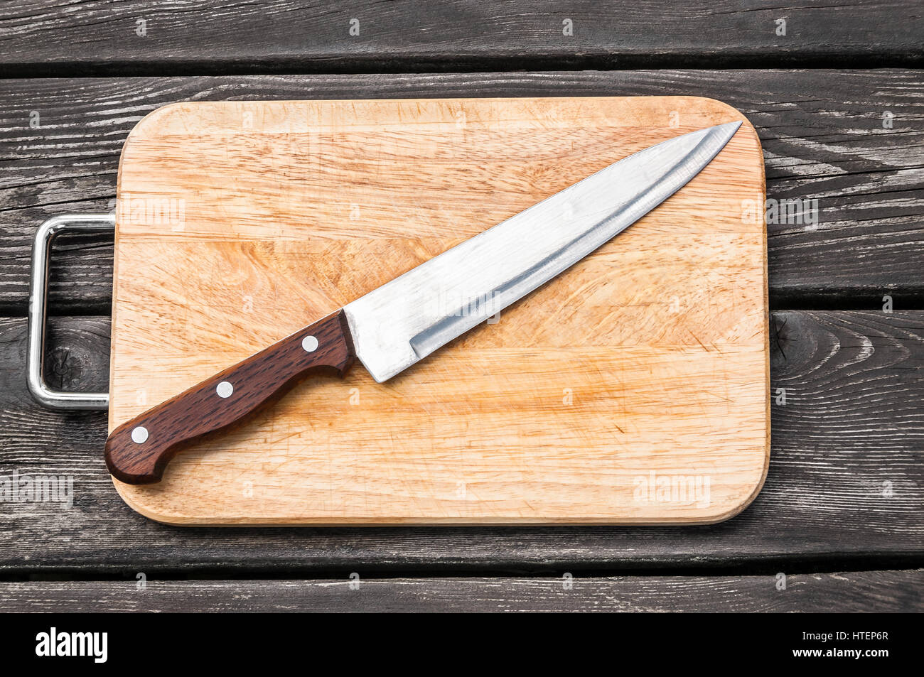 Couteau en acier sur une planche à découper sur fond de bois avec Banque D'Images
