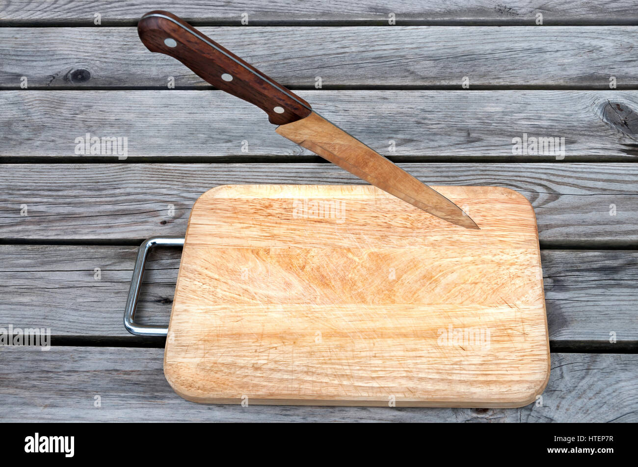 Planche à découper et couteau en acier sur une table en bois Banque D'Images