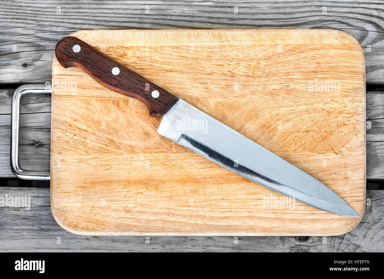 Planche à découper et couteau en acier sur une table en bois Banque D'Images