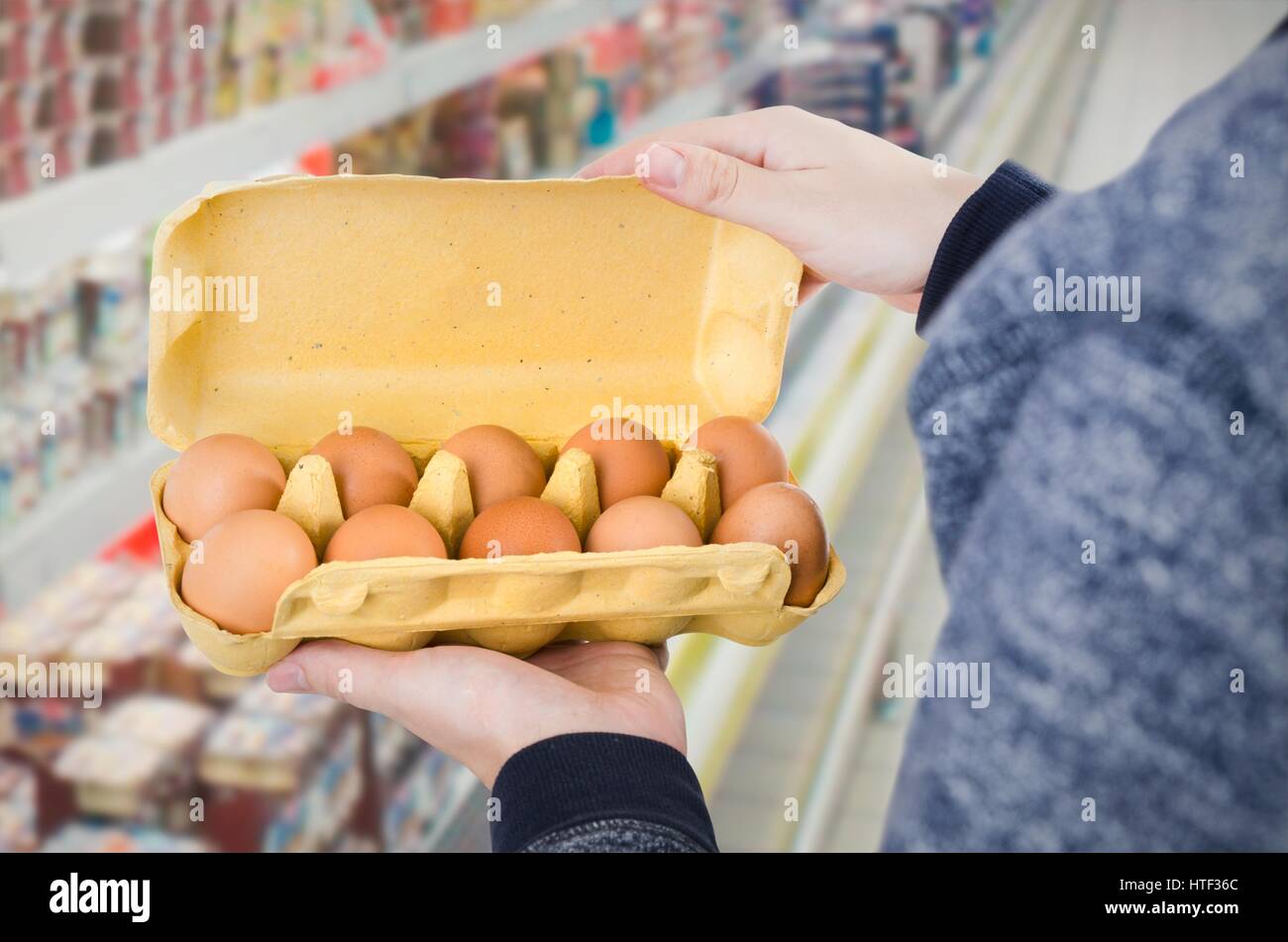 Man holding egg box en supermarché. boîte de carton d'oeufs acheter homme maintenir contrôle concept de consommation Banque D'Images