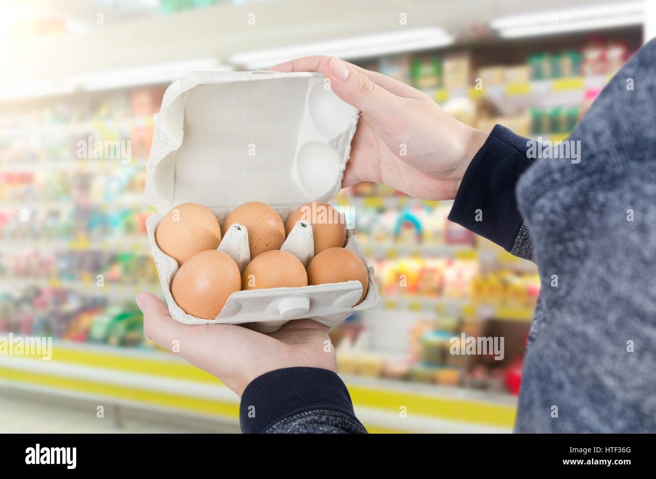Man holding egg box en supermarché. boîte de carton d'oeufs acheter homme maintenir contrôle concept de consommation Banque D'Images