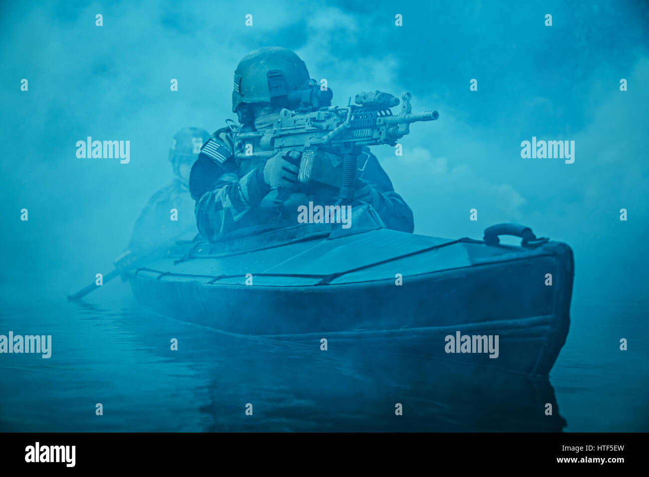 Les exploitants maritimes des Forces Spéciales en tenue de camouflage de l'armée de pagaie River kayak dans le brouillard. Mission de diversion, mitrailleur de l'avant Banque D'Images Les exploitants maritimes des Forces Spéciales en tenue de camouflage de l'armée de pagaie River kayak dans le brouillard. Mission de diversion, mitrailleur de l'avant Banque D'Images