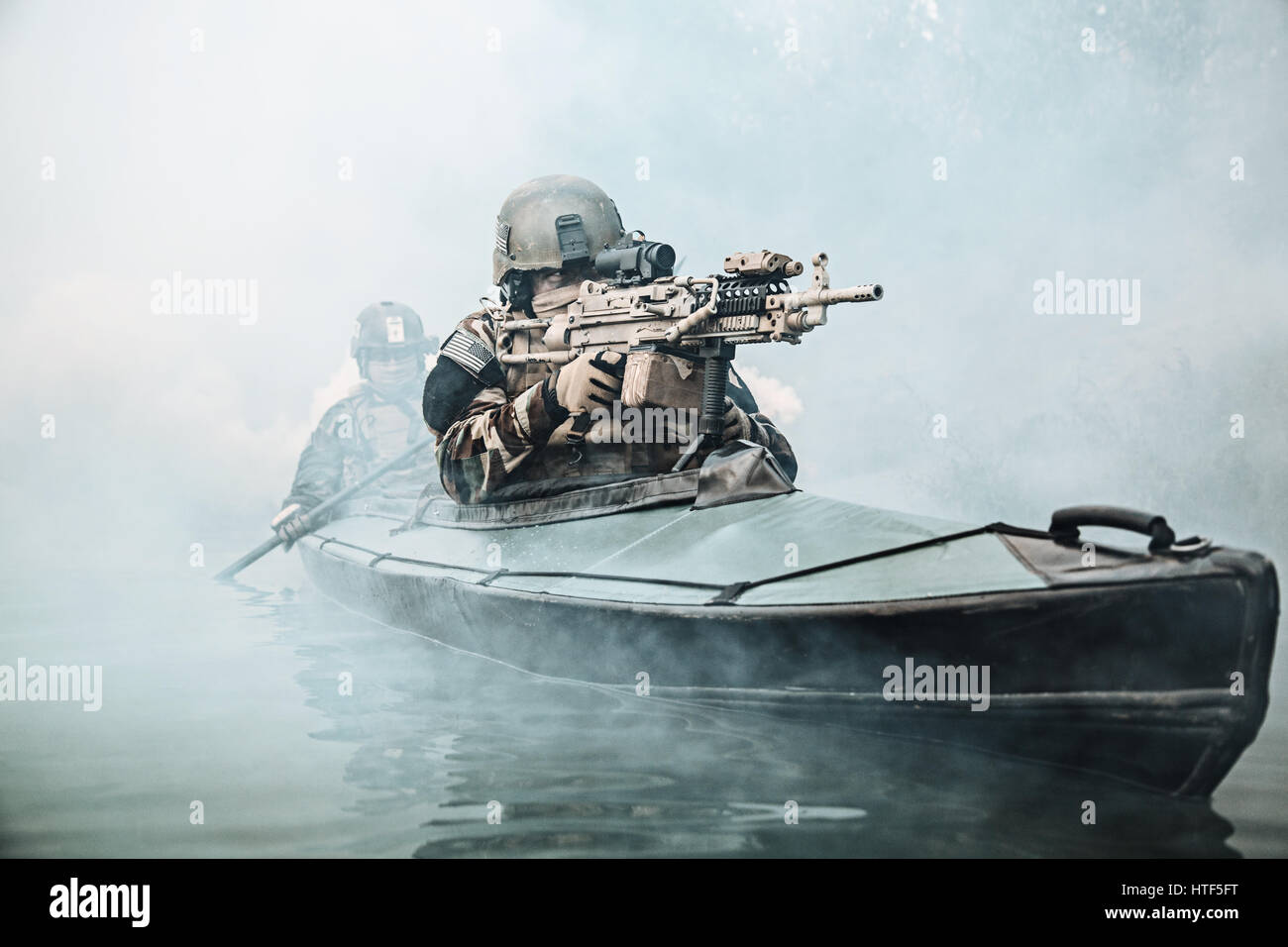 Les exploitants maritimes des Forces Spéciales en tenue de camouflage de l'armée de pagaie River kayak dans le brouillard. Mission de diversion, mitrailleur de l'avant Banque D'Images Les exploitants maritimes des Forces Spéciales en tenue de camouflage de l'armée de pagaie River kayak dans le brouillard. Mission de diversion, mitrailleur de l'avant Banque D'Images