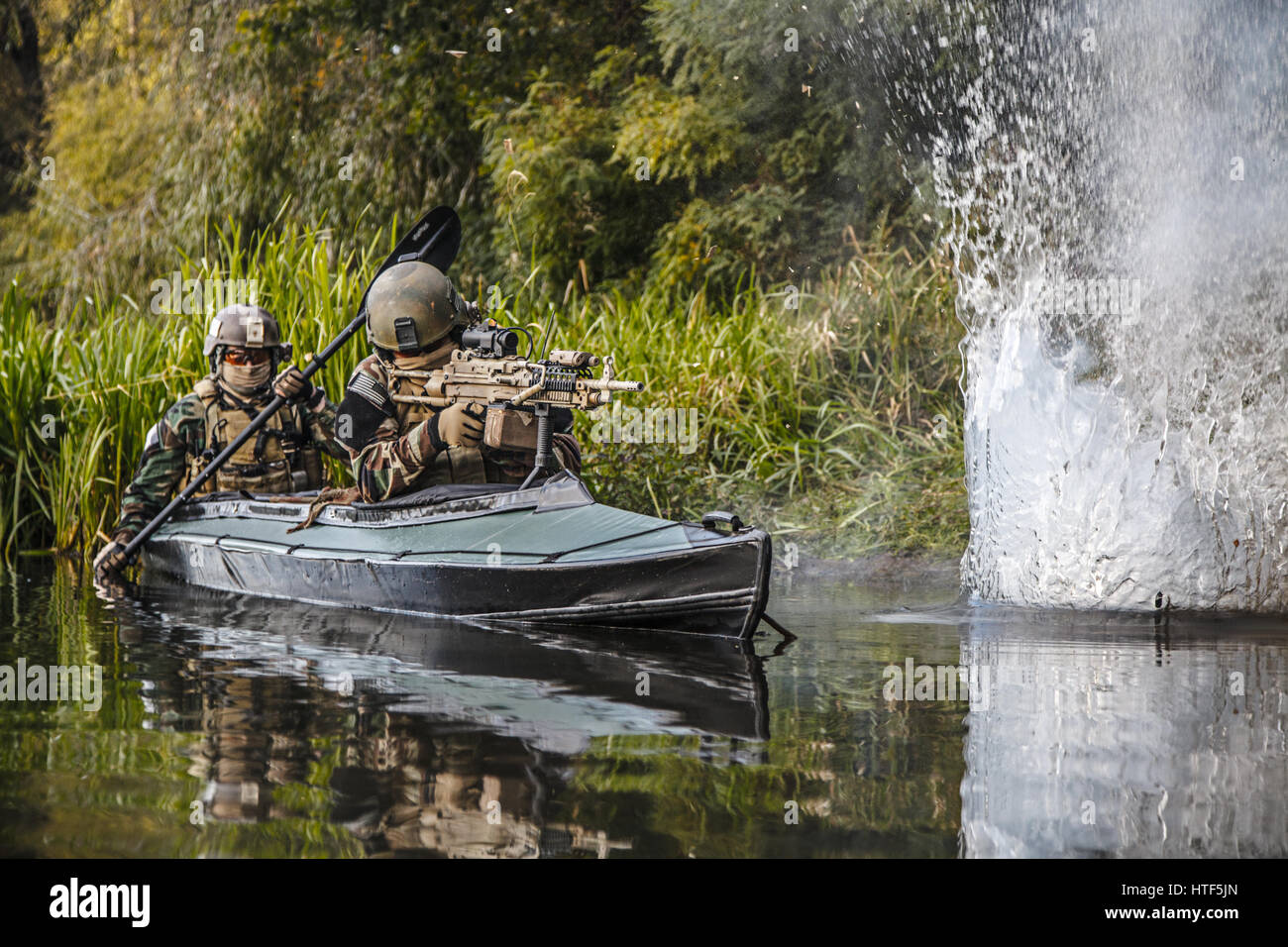 Les hommes des forces spéciales avec des visages peints en tenue de camouflage de l'armée de pagaie en kayak. Explosion d'une bombe à proximité soudaine au jet d'eau, Banque D'Images Les hommes des forces spéciales avec des visages peints en tenue de camouflage de l'armée de pagaie en kayak. Explosion d'une bombe à proximité soudaine au jet d'eau, Banque D'Images