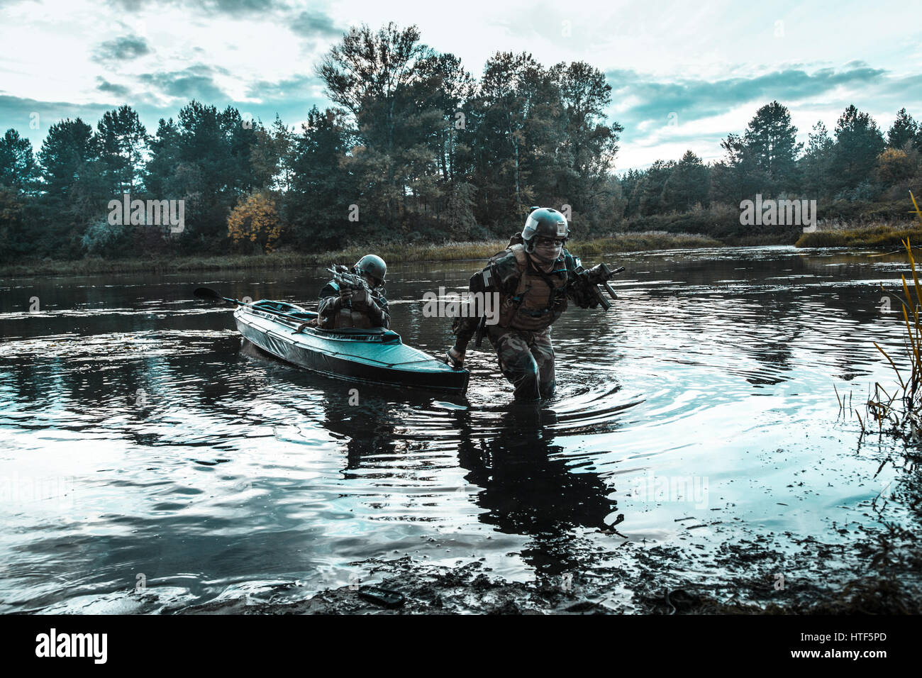 L'atterrissage clandestines. Paire d'opérateurs armés avec des visages peints de débarquement de la côte de la rivière kayak militaire . Mission de diversion sous le couvert de l'obscurité Banque D'Images L'atterrissage clandestines. Paire d'opérateurs armés avec des visages peints de débarquement de la côte de la rivière kayak militaire . Mission de diversion sous le couvert de l'obscurité Banque D'Images