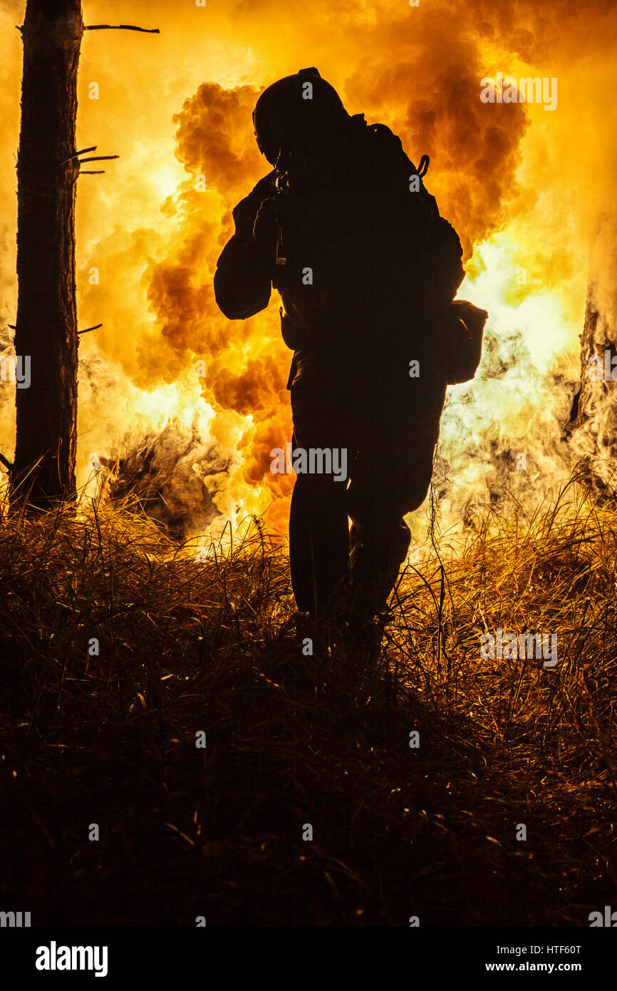 Silhouette en contre-jour des forces spéciales dans l'opérateur maritime sur fond d'explosion de feu de forêt. Bataille, des bombes qui explosent, les combats n'importe ce que Banque D'Images Silhouette en contre-jour des forces spéciales dans l'opérateur maritime sur fond d'explosion de feu de forêt. Bataille, des bombes qui explosent, les combats n'importe ce que Banque D'Images