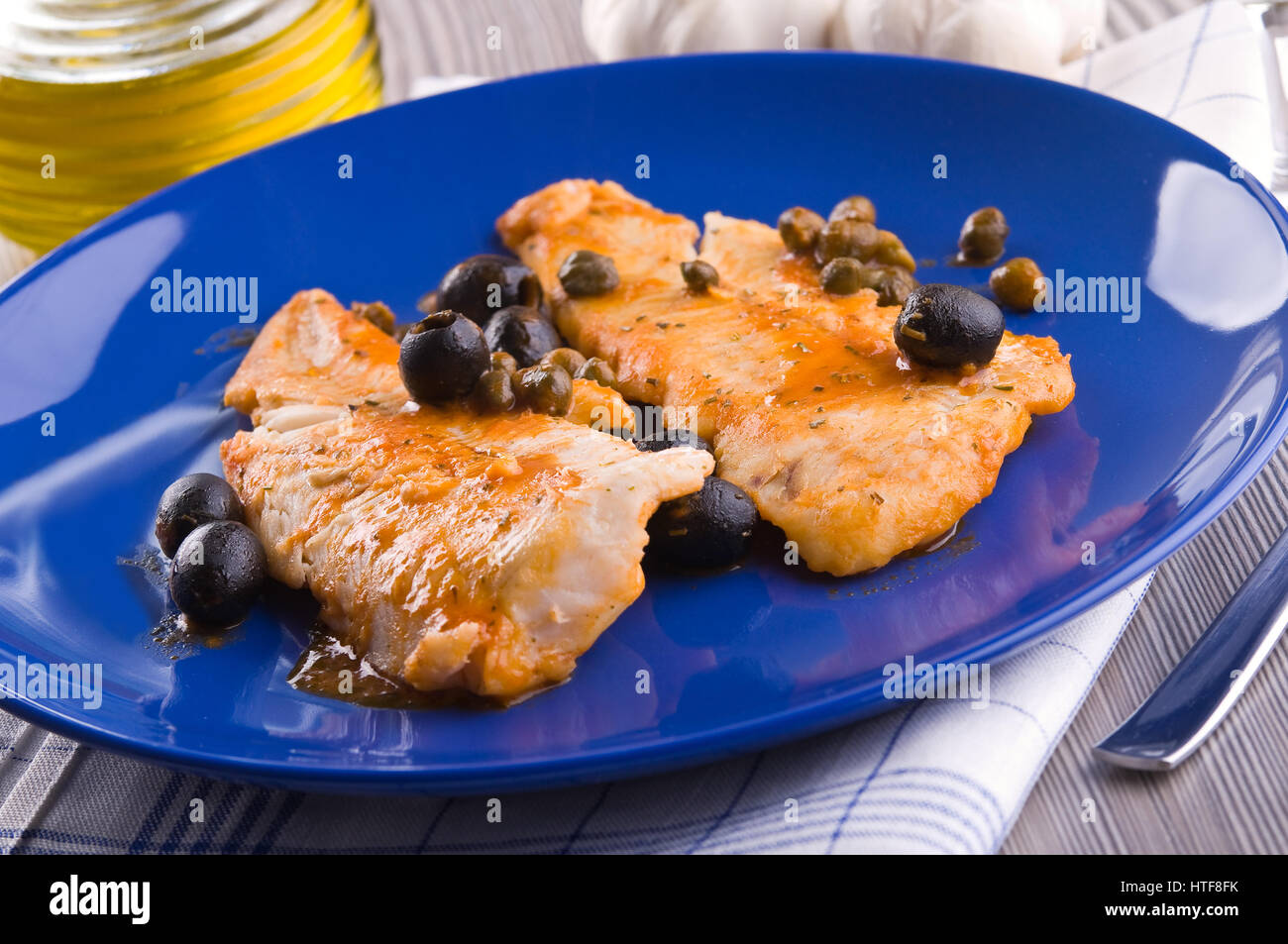 Filet de poisson avec des olives noires et des câpres. Banque D'Images