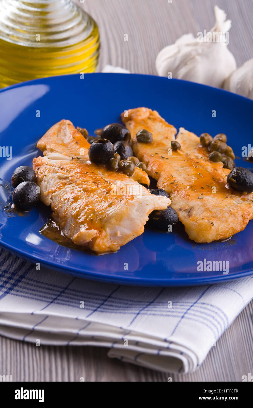 Filet de poisson avec des olives noires et des câpres. Banque D'Images