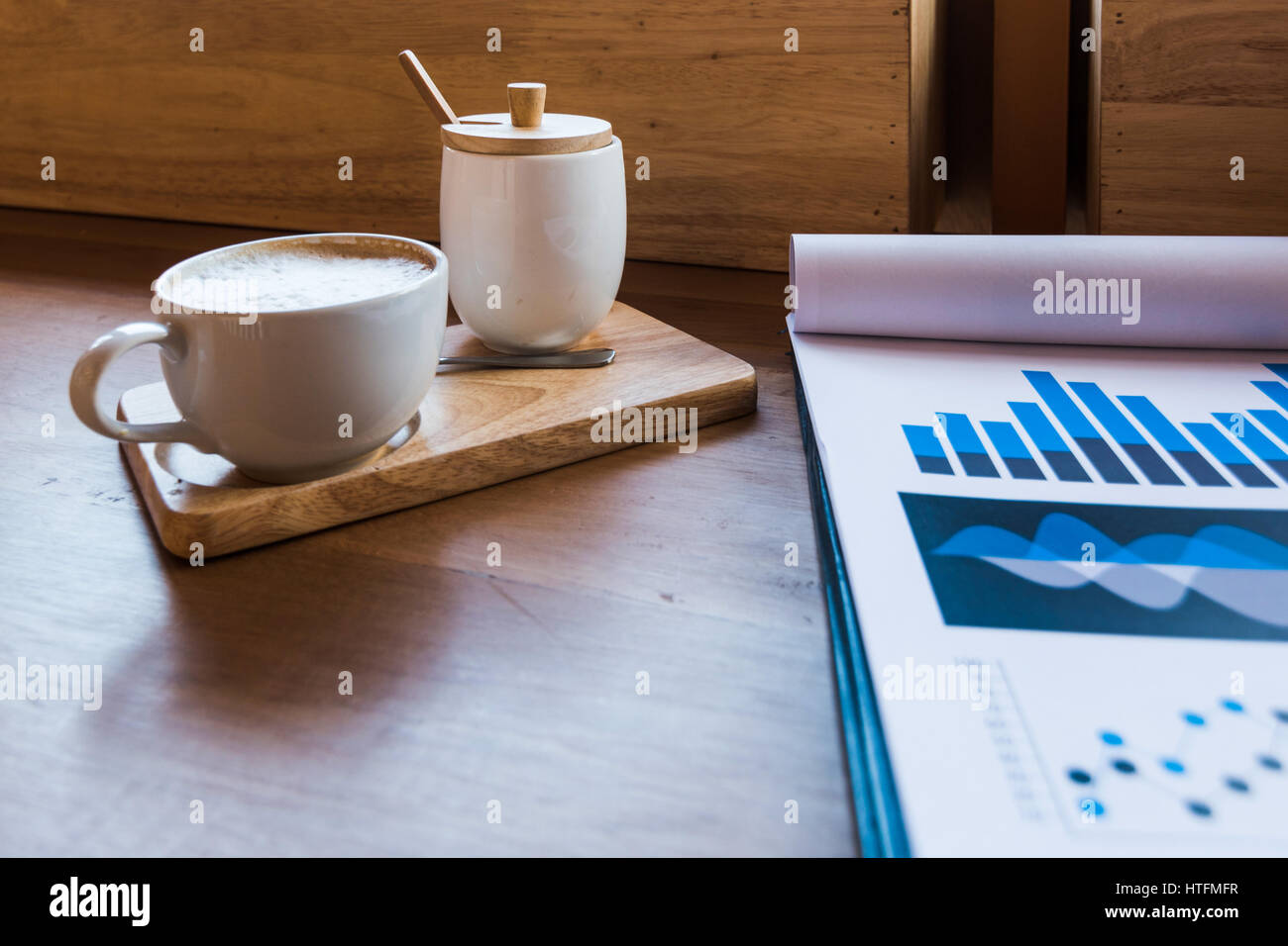 Tasse de café sur une table avec laptob graphique et diagramme des finances dans un coffee shop. Banque D'Images