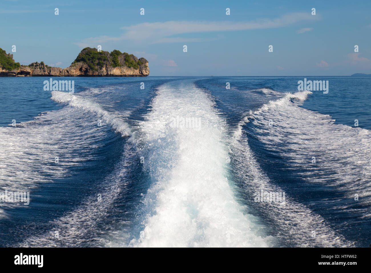 Les ondes d'un bateau à grande vitesse et de l'arrière-plan de l'île. Banque D'Images