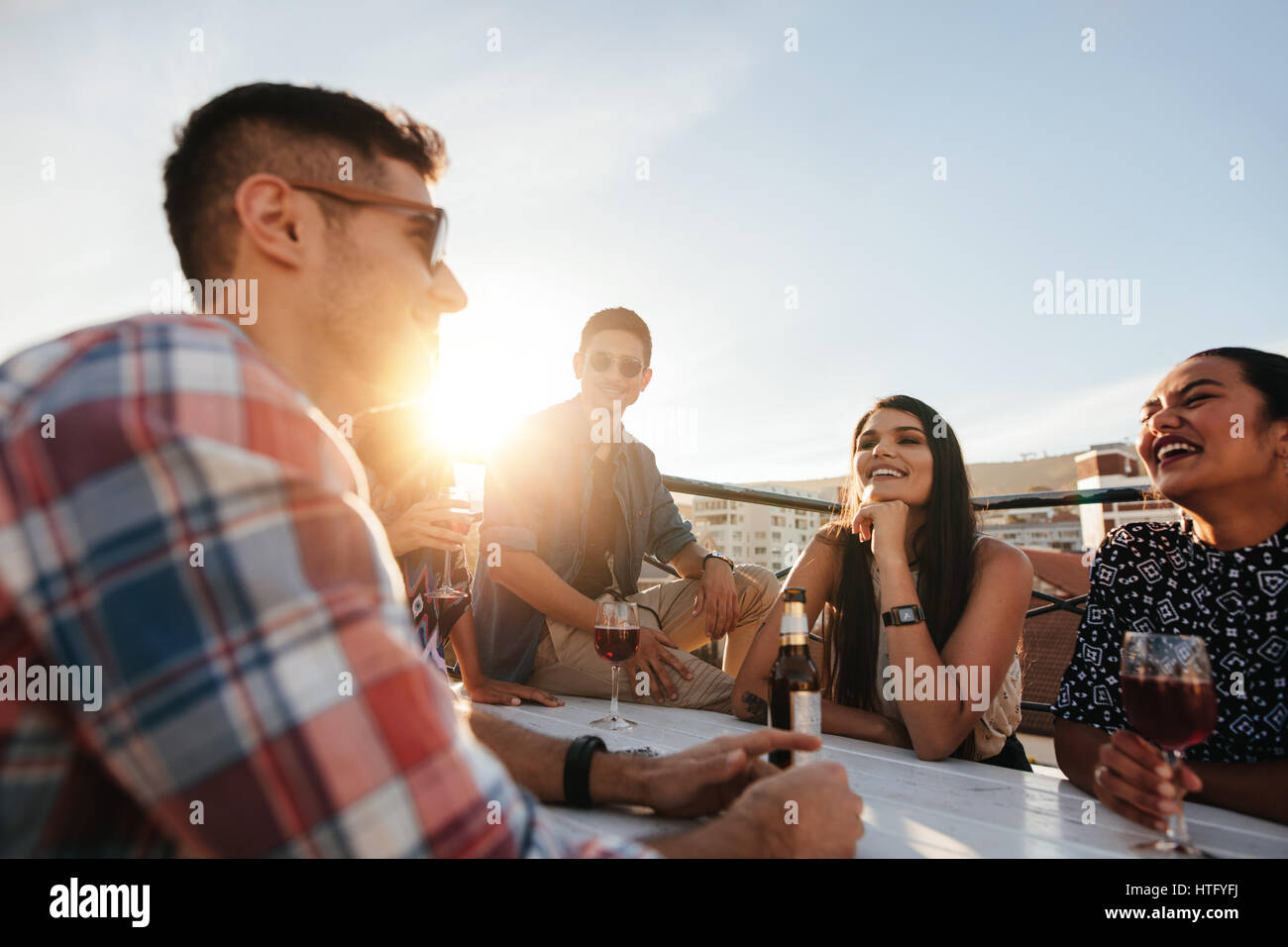 Shot of young woman having a rooftop party avec des amis. Parti d'amis sur le toit. Banque D'Images