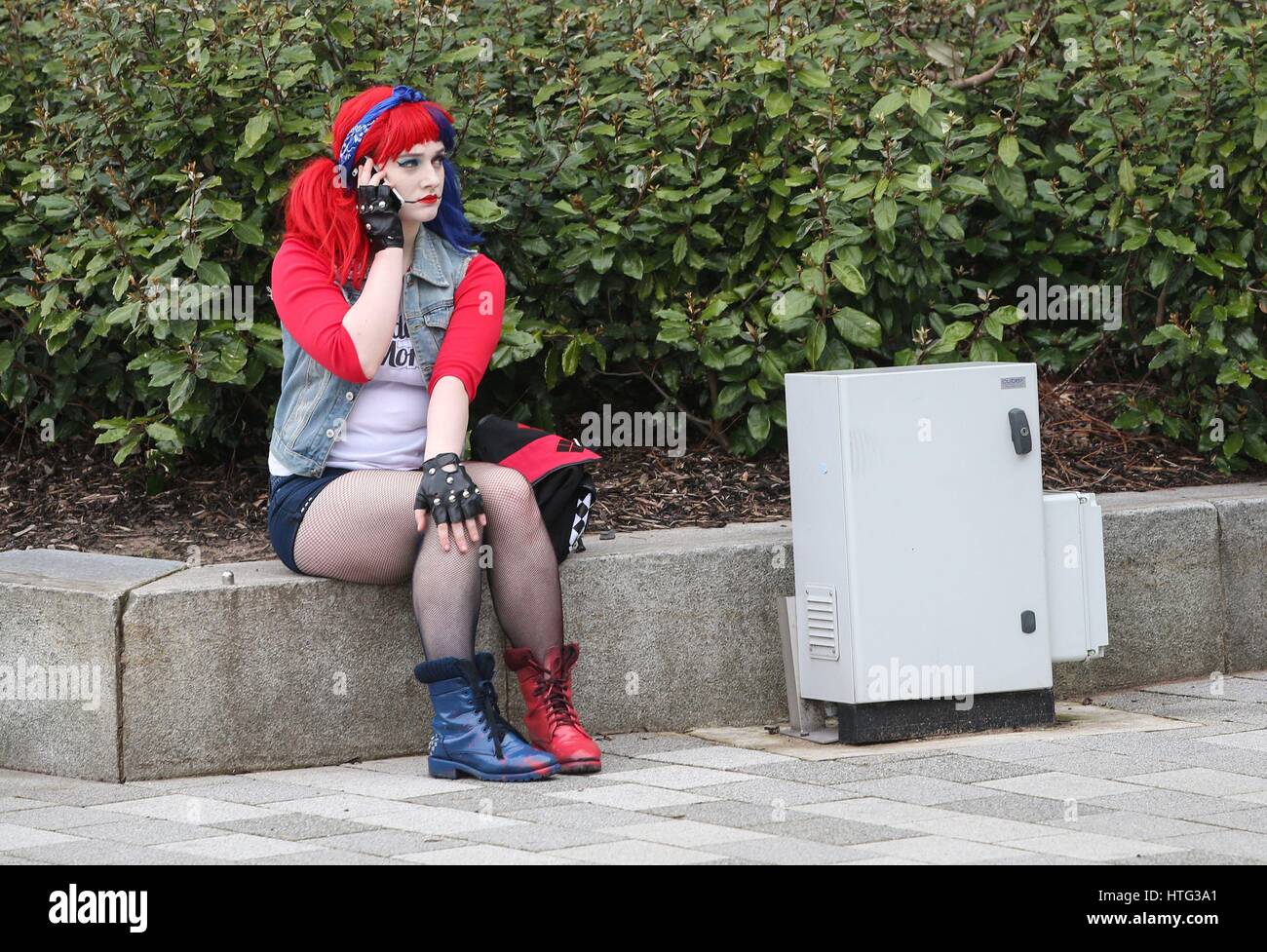 Une femme assise à l'extérieur de la MCM Comic Con au centre d'exposition de Liverpool. Banque D'Images