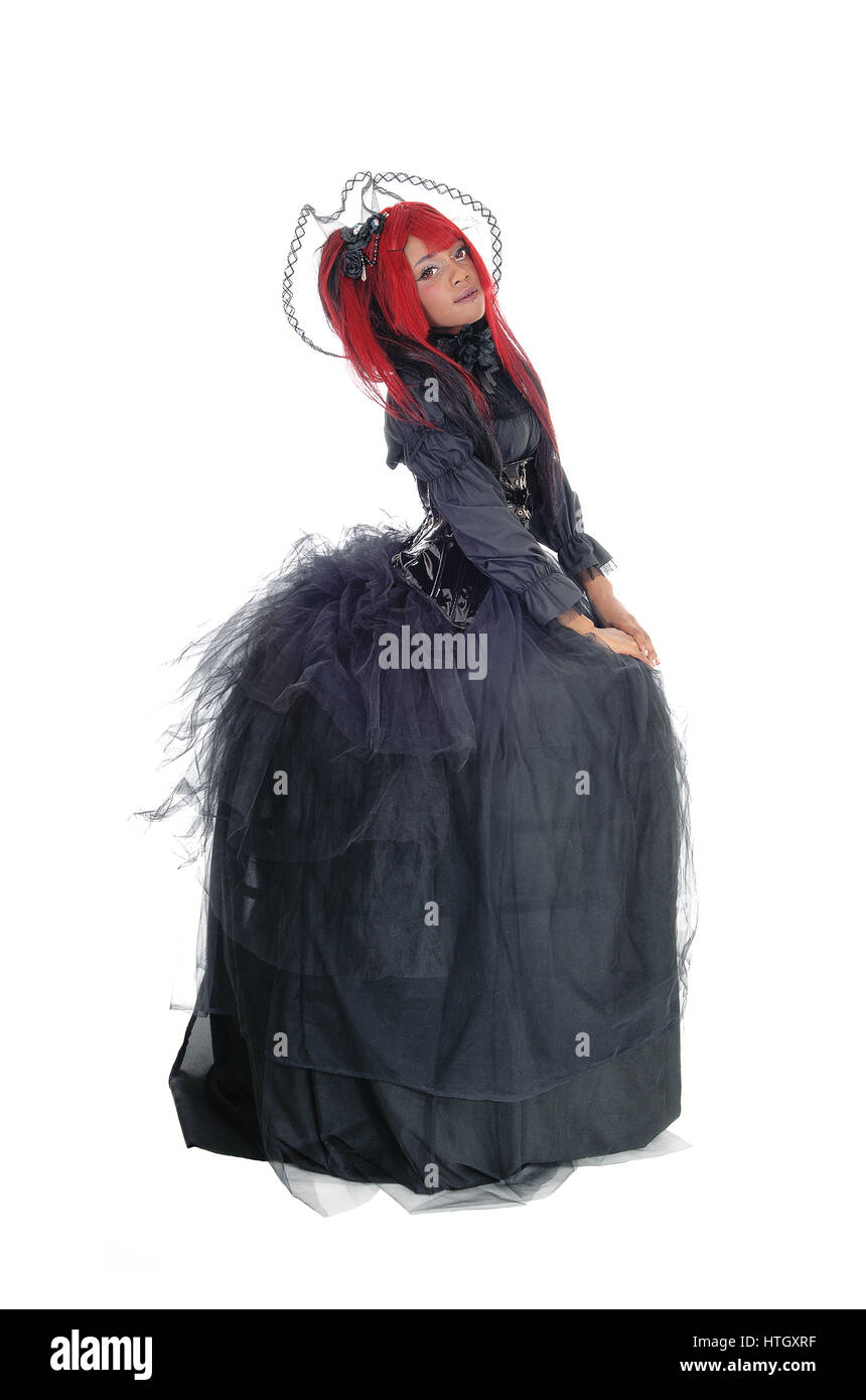 Une belle jeune femme africaine debout dans une longue robe noire et rouge victorien cheveux, isolée pour fond blanc. Banque D'Images