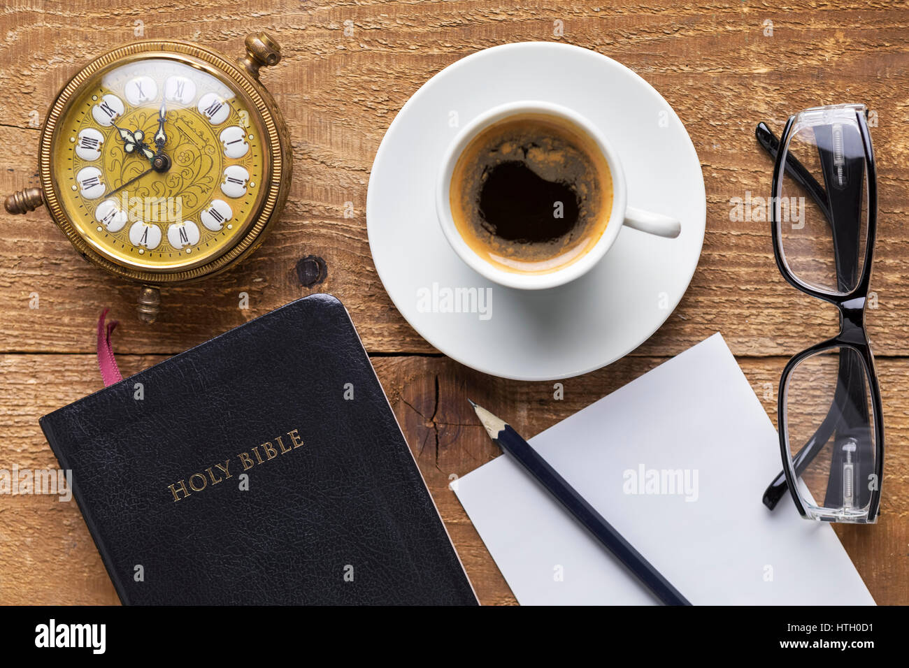 La Sainte Bible, réveil, verres et de café sur la table en bois. Concept d'étudier la Bible. L'accent sur la Bible Banque D'Images