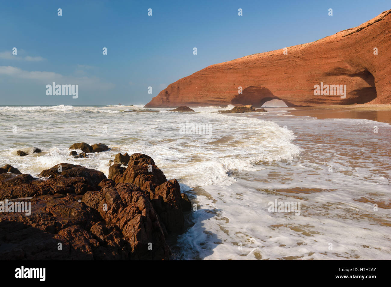Arcades rouge et plage de rochers dans l'océan Atlantique, dans la région Sous-Massa-Draa, Sidi Ifni, Legzira, Maroc, Afrique. Banque D'Images