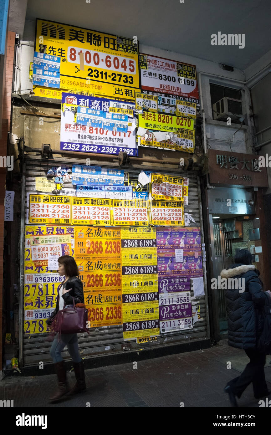 Des annonces immobilières couvrant l'avant du magasin de détail vide à hong kong Banque D'Images