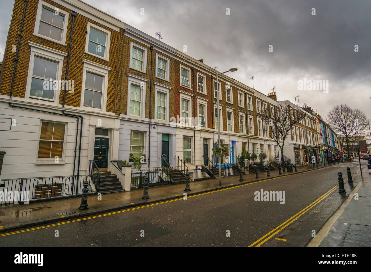 Rues de la célèbre Notting Hill avec de belles maisons et boutiques colorées contre un ciel nuageux. Londres, Royaume-Uni. Banque D'Images