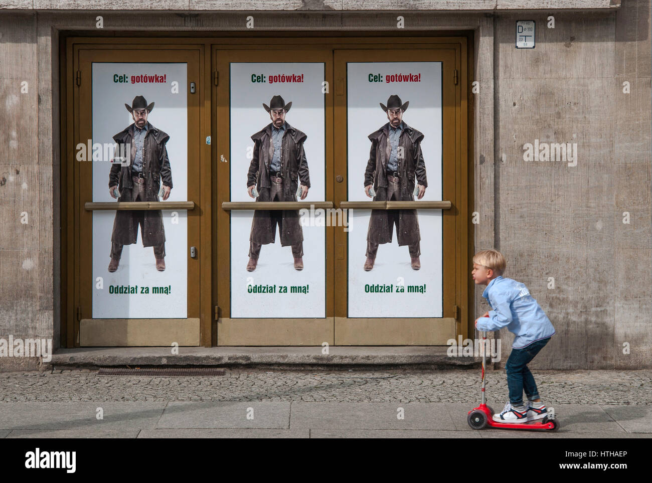 Garçon sur un scooter, traînent dans les rues, 'Cible : l'argent ! Suivez-moi !" les troupes de l'Acteur Chuck Norris affiche publicitaire pour Bank Zachodni WBK à Wroclaw, Pologne Banque D'Images