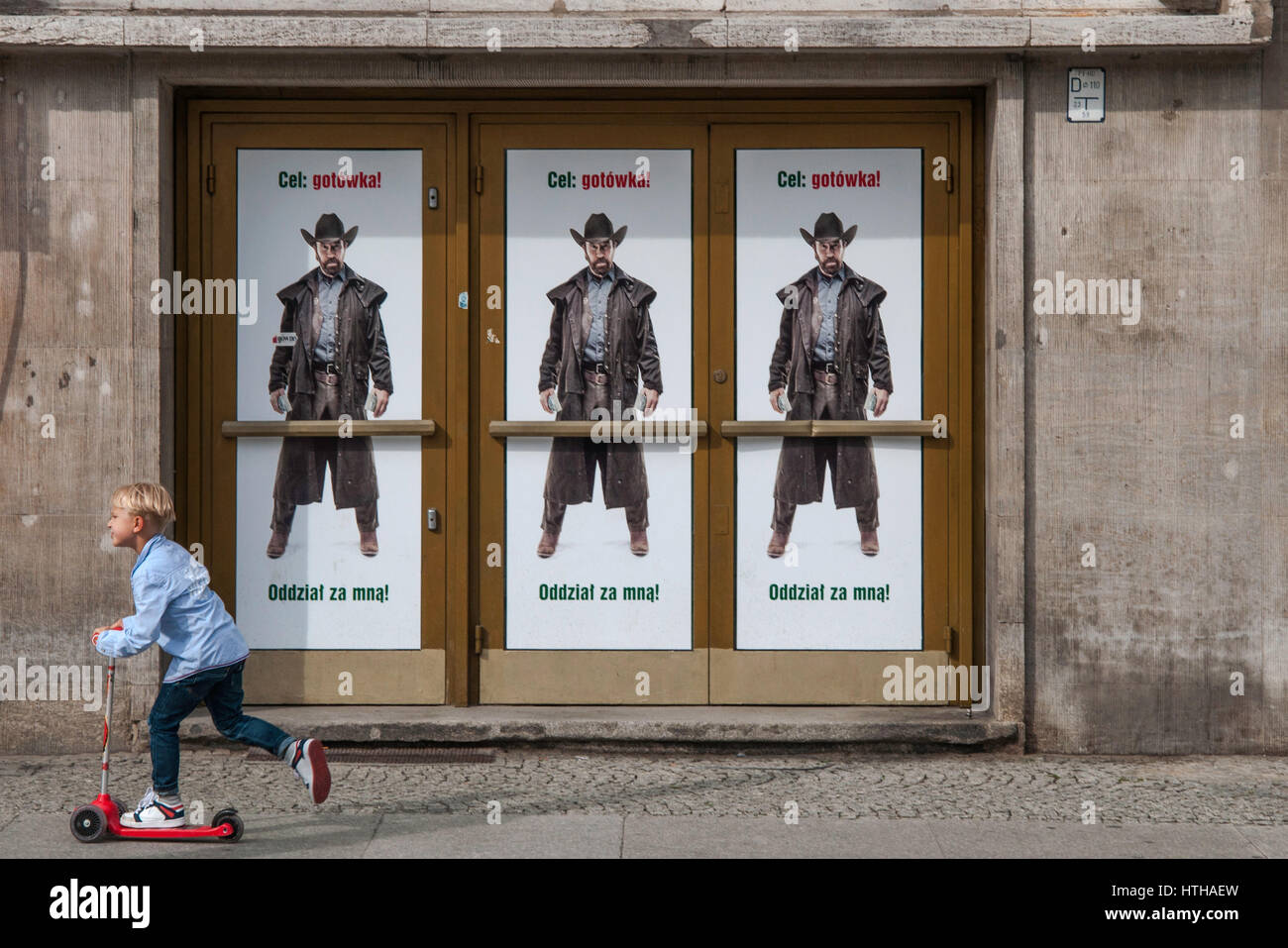 Garçon sur un scooter, traînent dans les rues, 'Cible : l'argent ! Suivez-moi !" les troupes de l'Acteur Chuck Norris affiche publicitaire pour Bank Zachodni WBK à Wroclaw, Pologne Banque D'Images
