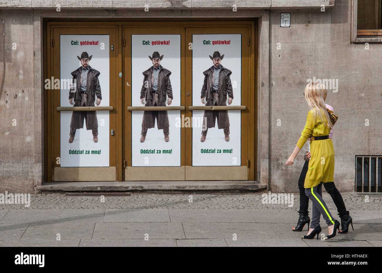 Deux jeunes femmes blondes en marche 'Cible : l'argent ! Suivez-moi !" les troupes de l'Acteur Chuck Norris dans l'affiche publicitaire pour Bank Zachodni WBK à Wroclaw, Pologne Banque D'Images