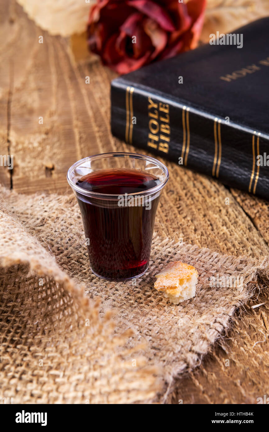 Prendre la communion. Tasse de verre avec du pain et du vin sur la table de la bible de près. Se concentrer sur le verre Banque D'Images