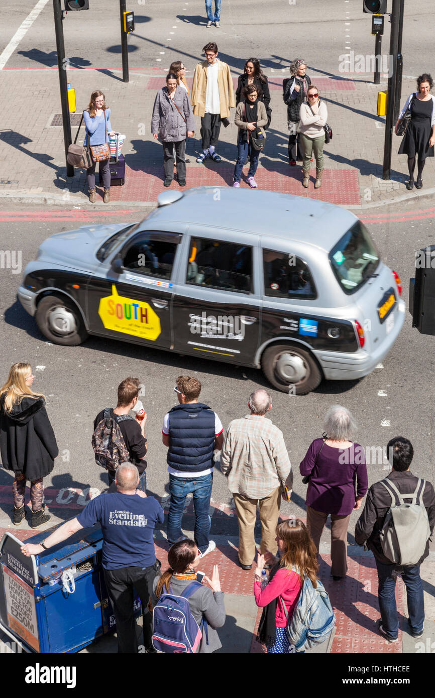 Les gens qui attendent pour traverser la rue, London, England, UK Banque D'Images