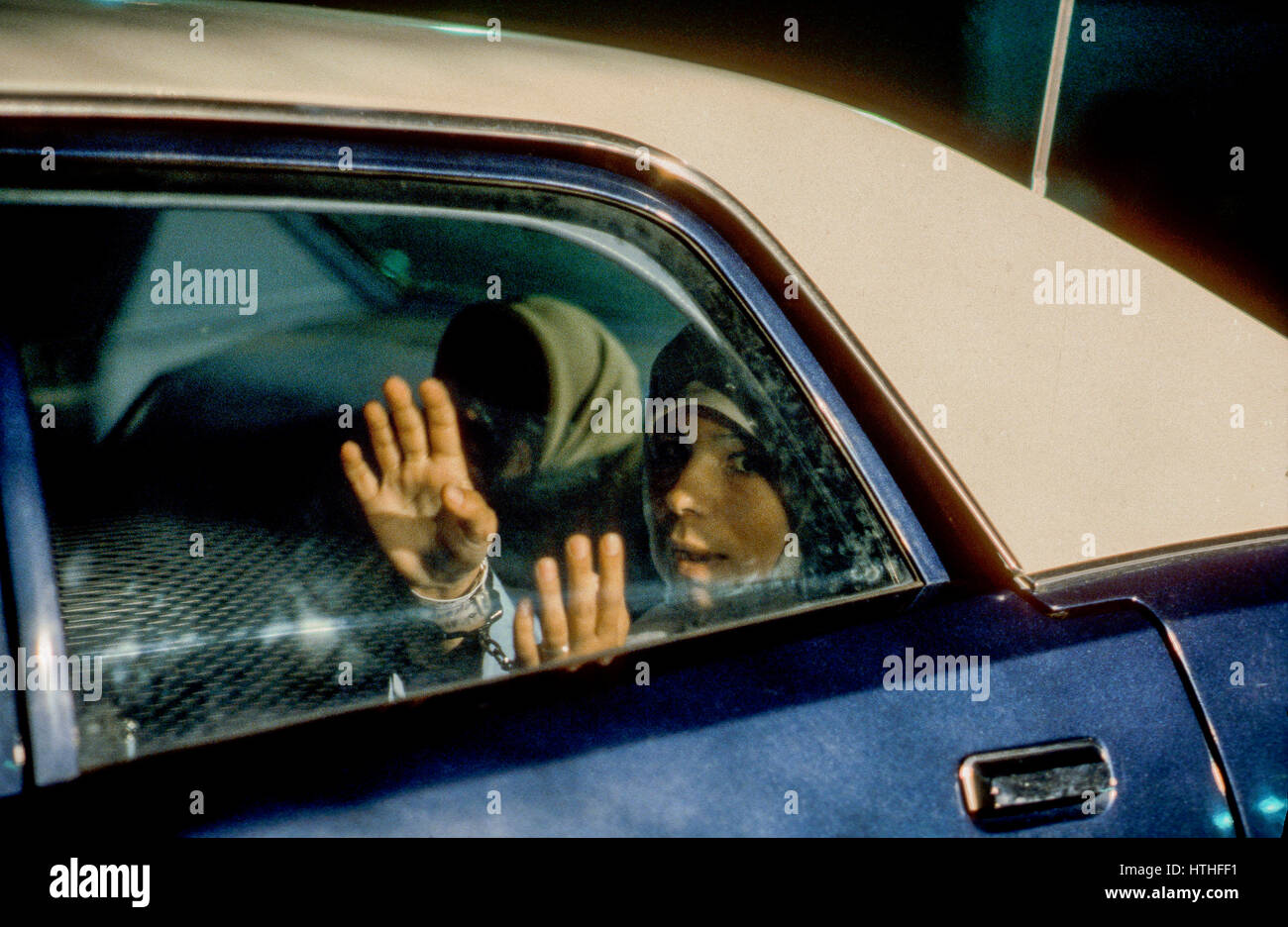 Deux femmes iraniennes illégales les étudiants qui ont dépassé leur visa d'étudiant sont menottés et placés dans la banquette arrière d'une voiture de police à prendre en prison après avoir été arrêté par des agents de l'immigration de Washington DC., 1979. Photo par Mark Reinstein Banque D'Images