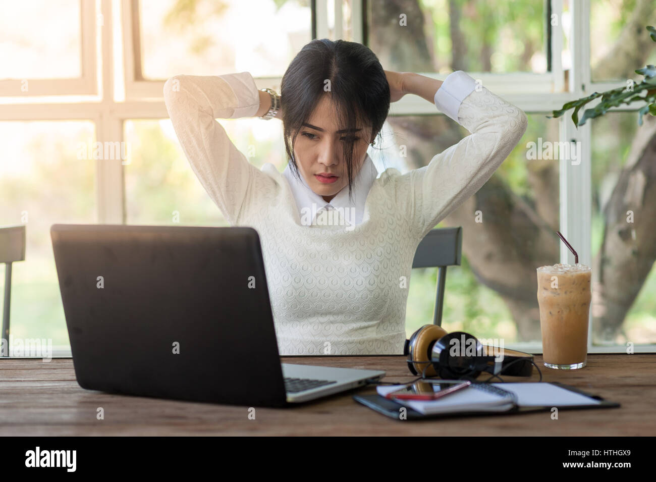 Jeune femme asiatique travailleur indépendant en faisant une pause tout en travaillant avec un ordinateur portable dans un café. L'entreprise de démarrage ou à une activité indépendante d'hiver Banque D'Images