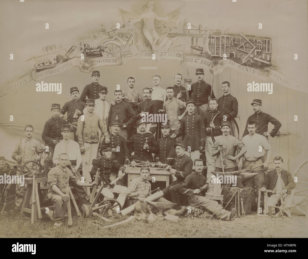 1898 professionnels anciens photo de 4e Régiment du génie, Grenoble, France, soldats, d'ouvriers vêtus d'uniformes et de vêtements de travail. Notez les différentes forgeron, découpage, perçage et d'outils de mesure, les machines avec des engrenages (pignons, roues dentées), enclumes, d'avions et de scies multiples. Aussi, l'avis d'un enfant, un vélo, un singe, modèle cinématique, un boîtier d'horloge et d'une boussole de l'outil. Source : cabinet collage photo prise et composée par Leon Pineau. Banque D'Images