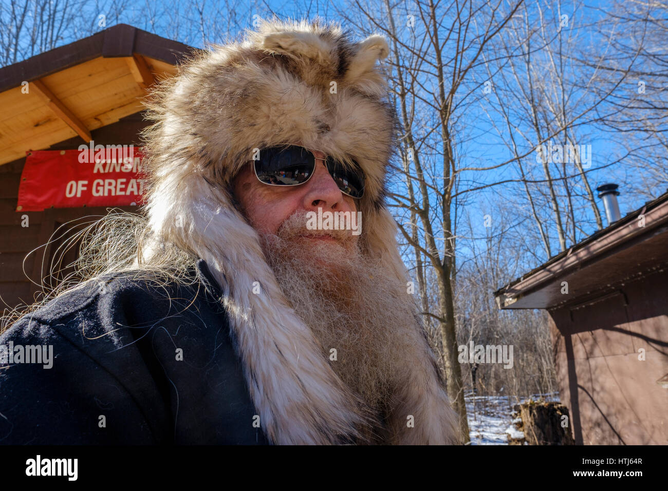 Homme barbu, barbe grise, les cheveux gris, l'homme d'âge moyen portant le coyote (Canis latrans) / fourrure fourrure hat, rugueux à la recherche, à London, Ontario, Canada. Banque D'Images