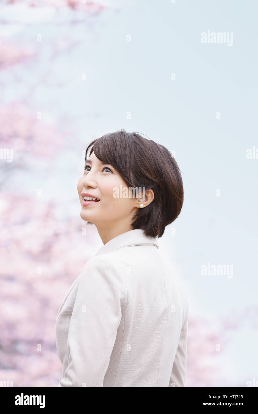 Femme japonaise avec fleurs de cerisier dans un parc de la ville Banque D'Images