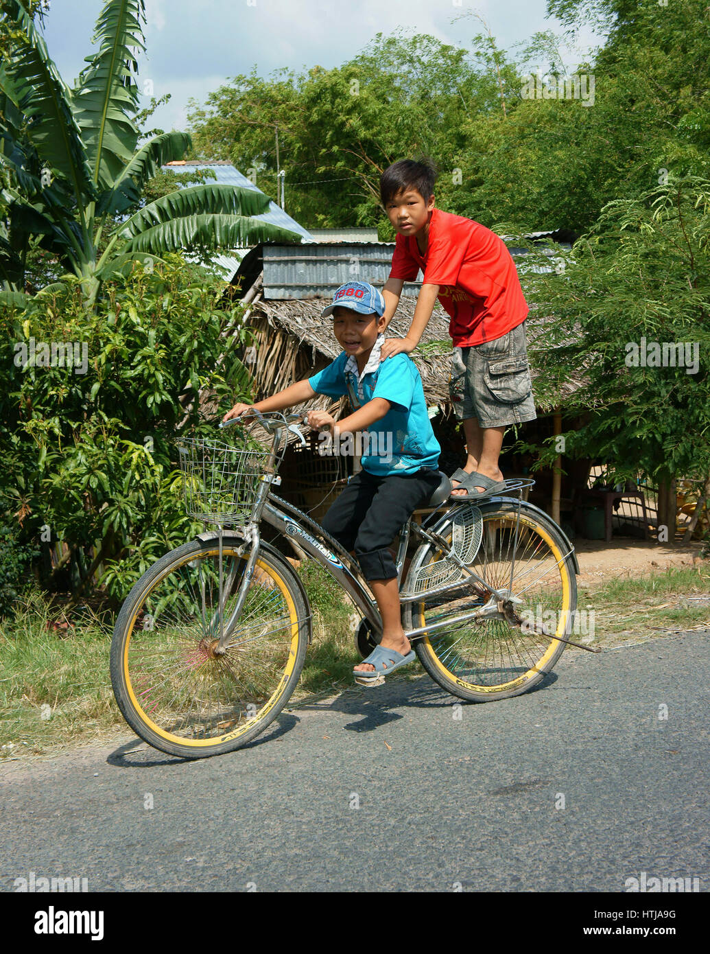 DONG THAP, VIET NAM- SEPT 23, 2014 : deux inconnus Asian kid circuler à bicyclette sur les routes de campagne, en situation de danger, les enfants vietnamiens vélo très dang Banque D'Images