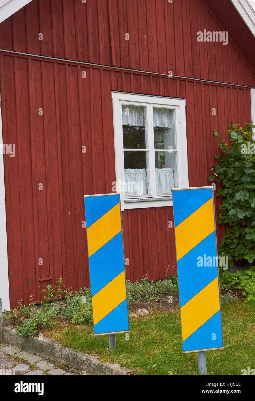 Bleu et jaune de la signalisation routière par maison traditionnelle en bois, Sigtuna, Suède, Scandinavie Banque D'Images