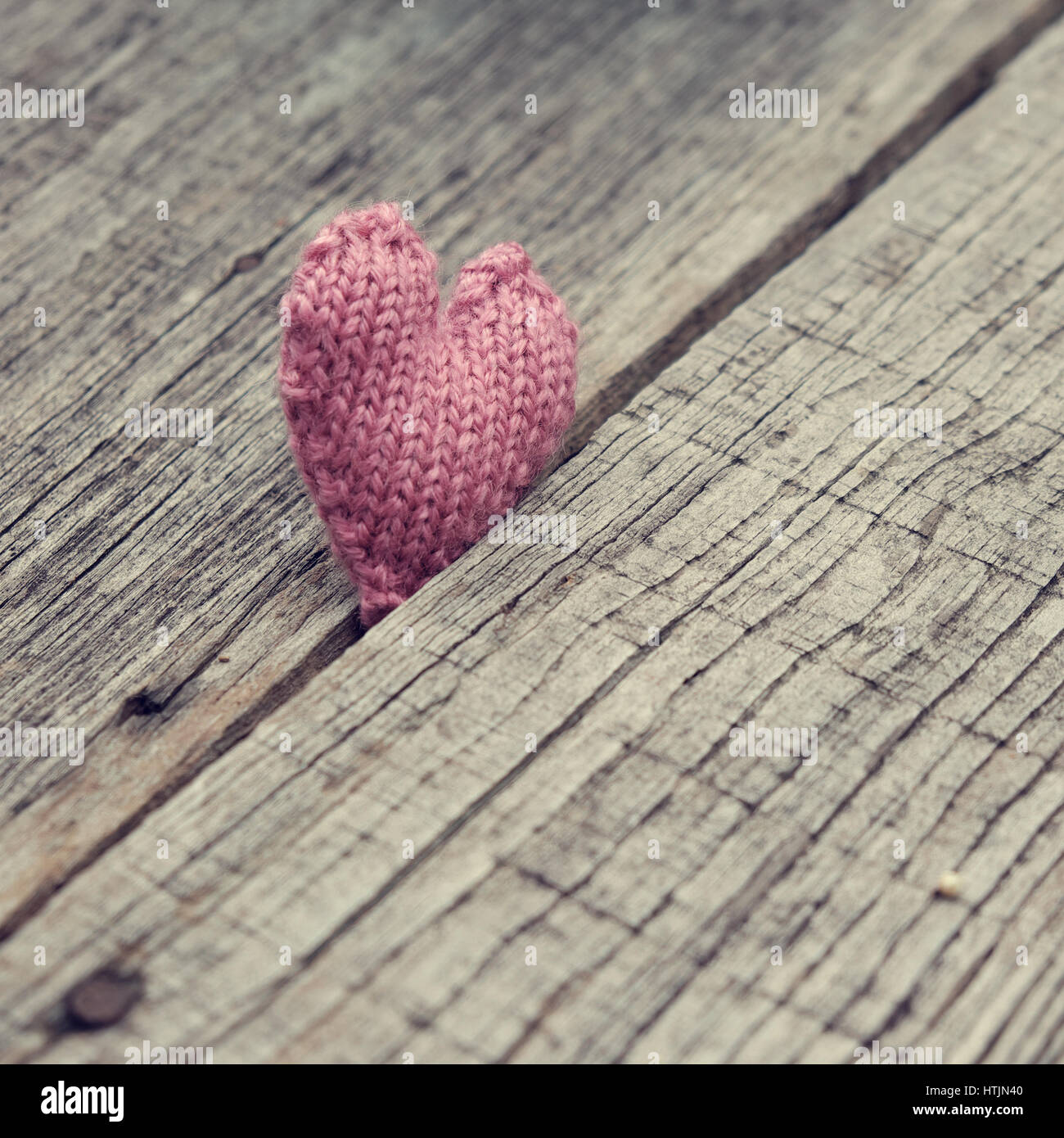 Lonely Heart sur fond de bois, symbole de l'amour avec coeur tricoté en rose couleur vintage Banque D'Images