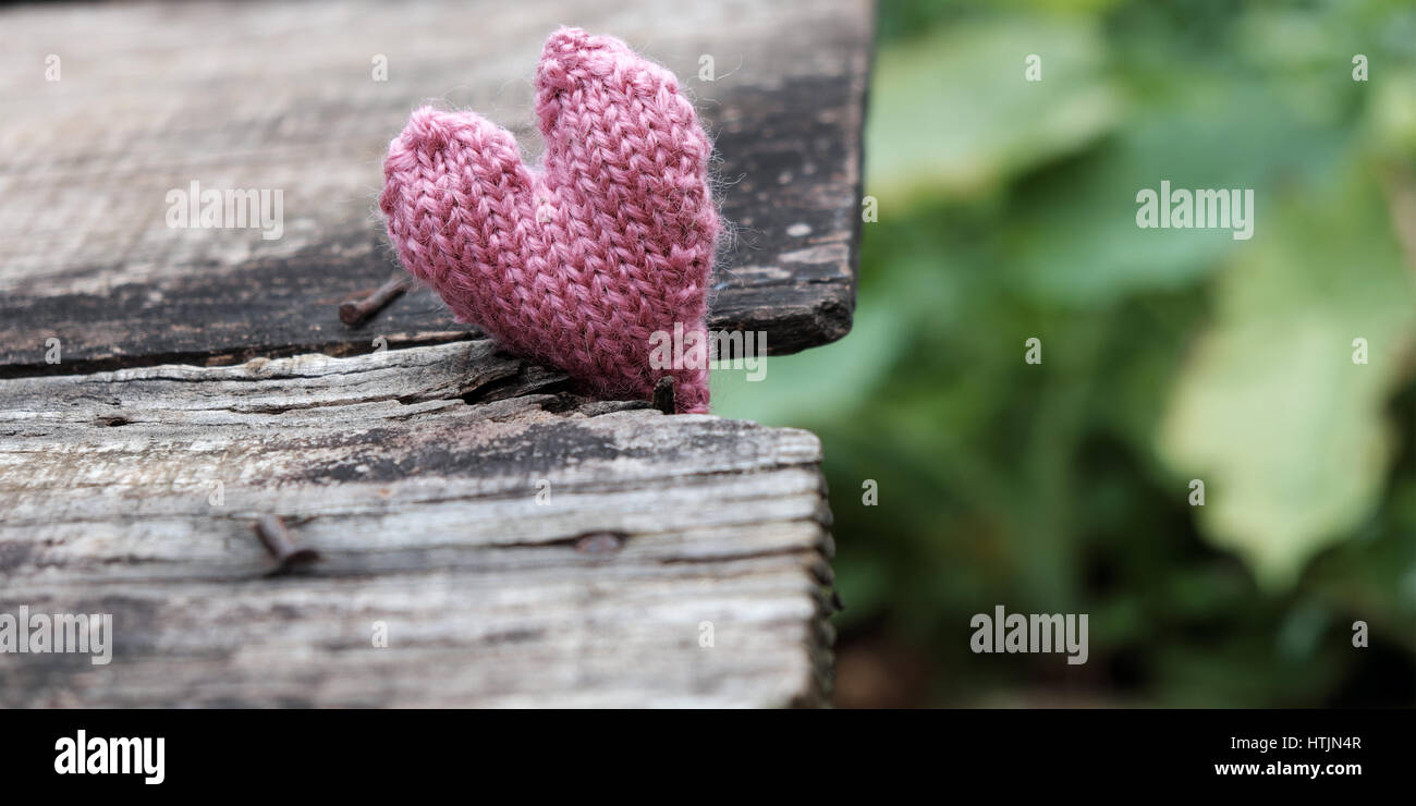 Lonely Heart sur fond de bois, symbole de l'amour avec coeur tricoté en rose couleur vintage Banque D'Images