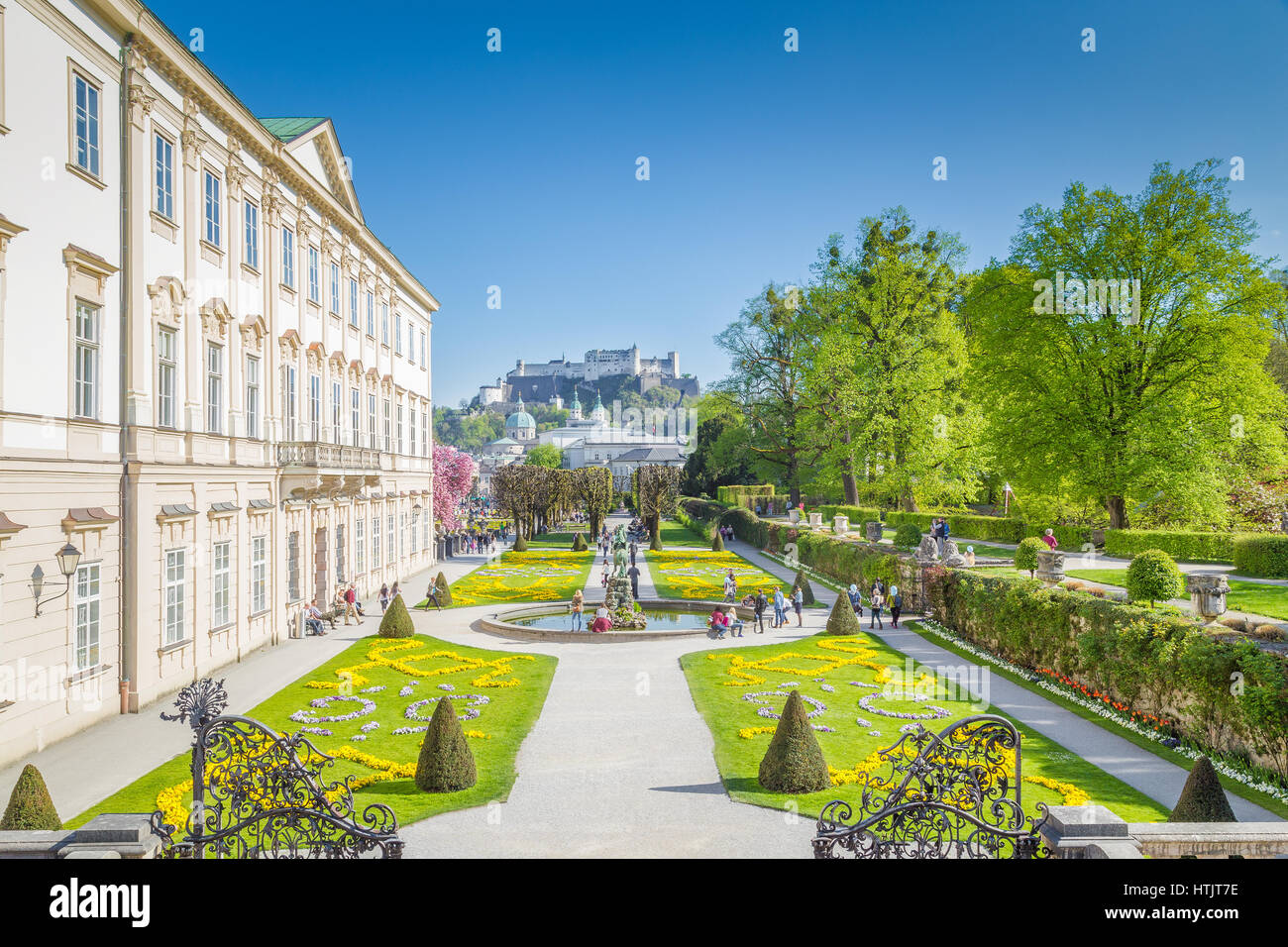 Les touristes en se promenant dans les jardins Mirabell célèbre avec célèbre forteresse de Hohensalzburg en arrière-plan sur une journée ensoleillée en été, Salzbourg, Autriche Banque D'Images