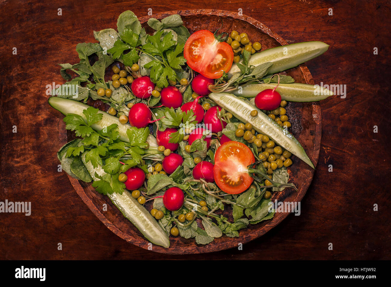 Vue de dessus de la salade de concombres, tomates et les verts sur une plaque de bois Banque D'Images