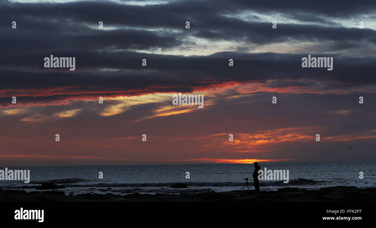 Un photographe s'apprête à capturer le lever du soleil à Whitley Bay, Tyne et Wear, comme aujourd'hui pourrait être l'un des jours les plus chauds de l'année jusqu'à présent avec un peu plus de ressort dans une semaine. Banque D'Images