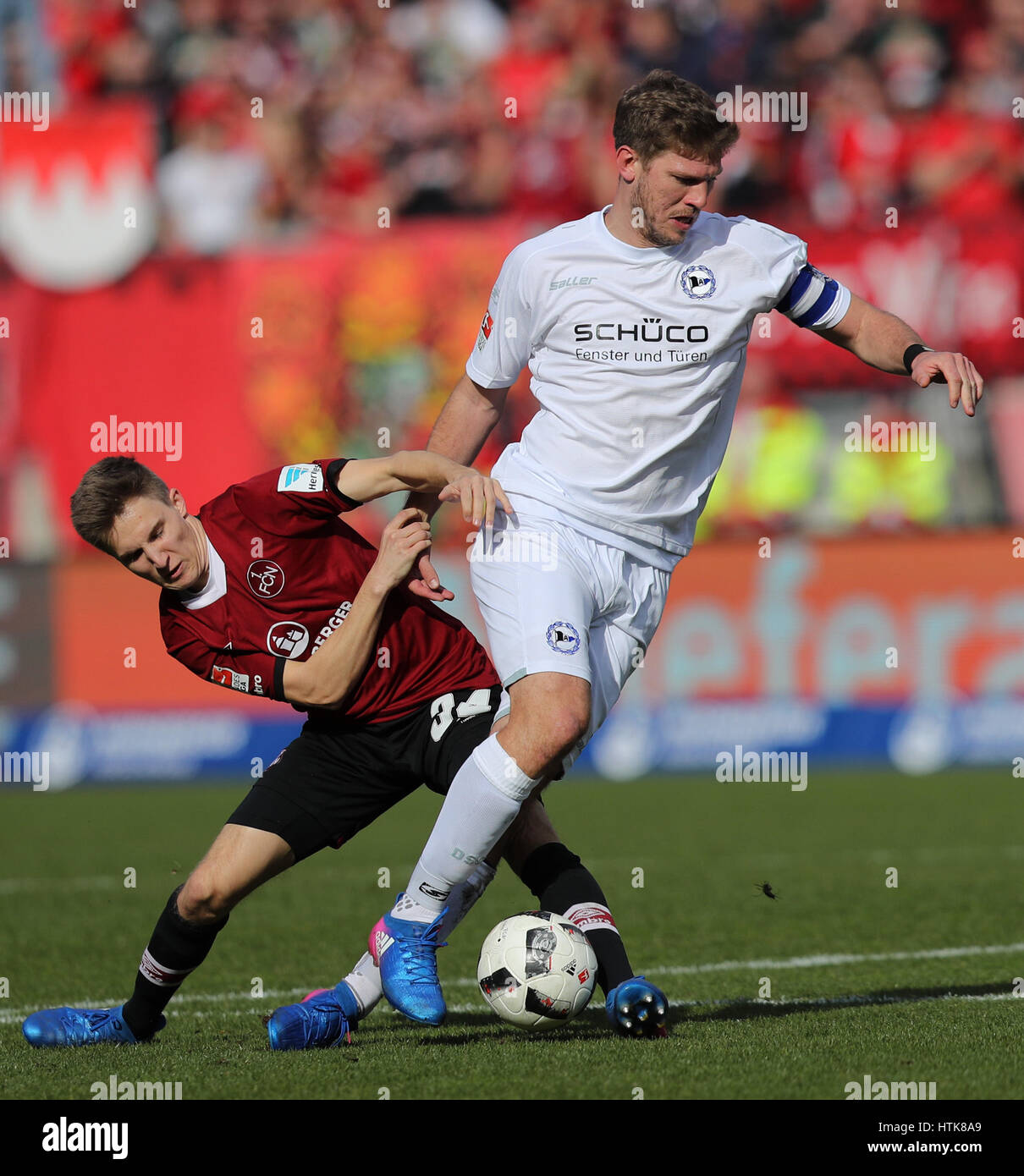 Nuremberg, Allemagne. Mar 12, 2017. Le Dennis Lippert (L) et Bielefeld's Fabian Klos rivalisent pour le ballon pendant le match de football Bundesliga 2 allemande entre 1. FC Nuremberg et l'Arminia Bielefeld dans le stade Grundig à Nuremberg, Allemagne, 12 mars 2017. (CONDITIONS D'EMBARGO - ATTENTION : En raison de l'accréditation, le LDF guidlines n'autorise la publication et l'utilisation de jusqu'à 15 photos par correspondance sur internet et dans les médias en ligne pendant le match.) Photo : Daniel Karmann/dpa/Alamy Live News Banque D'Images