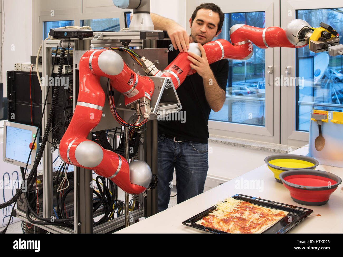 Brême, Allemagne. Mar 8, 2017. Assistant de recherche Gheorghe Lisca permet à un robot de l'institut de recherche 'l'Intelligence Artificielle (IA)' pizza à l'université de Brême, Allemagne, le 8 mars 2017. Les scientifiques de l'ordinateur et le robot en ce moment tenter de modifier et programmer des robots afin de les aider dans la cuisine, entre autres. Photo : Ingo Wagner/dpa/Alamy Live News Banque D'Images