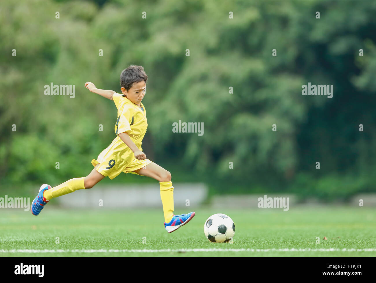 Enfant jouant au football japonais Banque D'Images