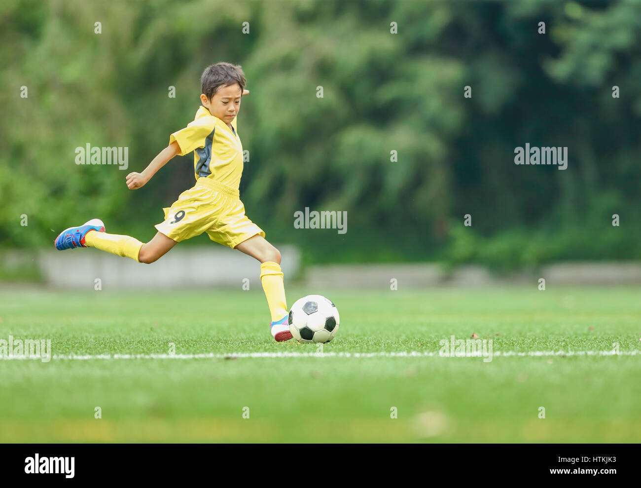 Enfant jouant au football japonais Banque D'Images
