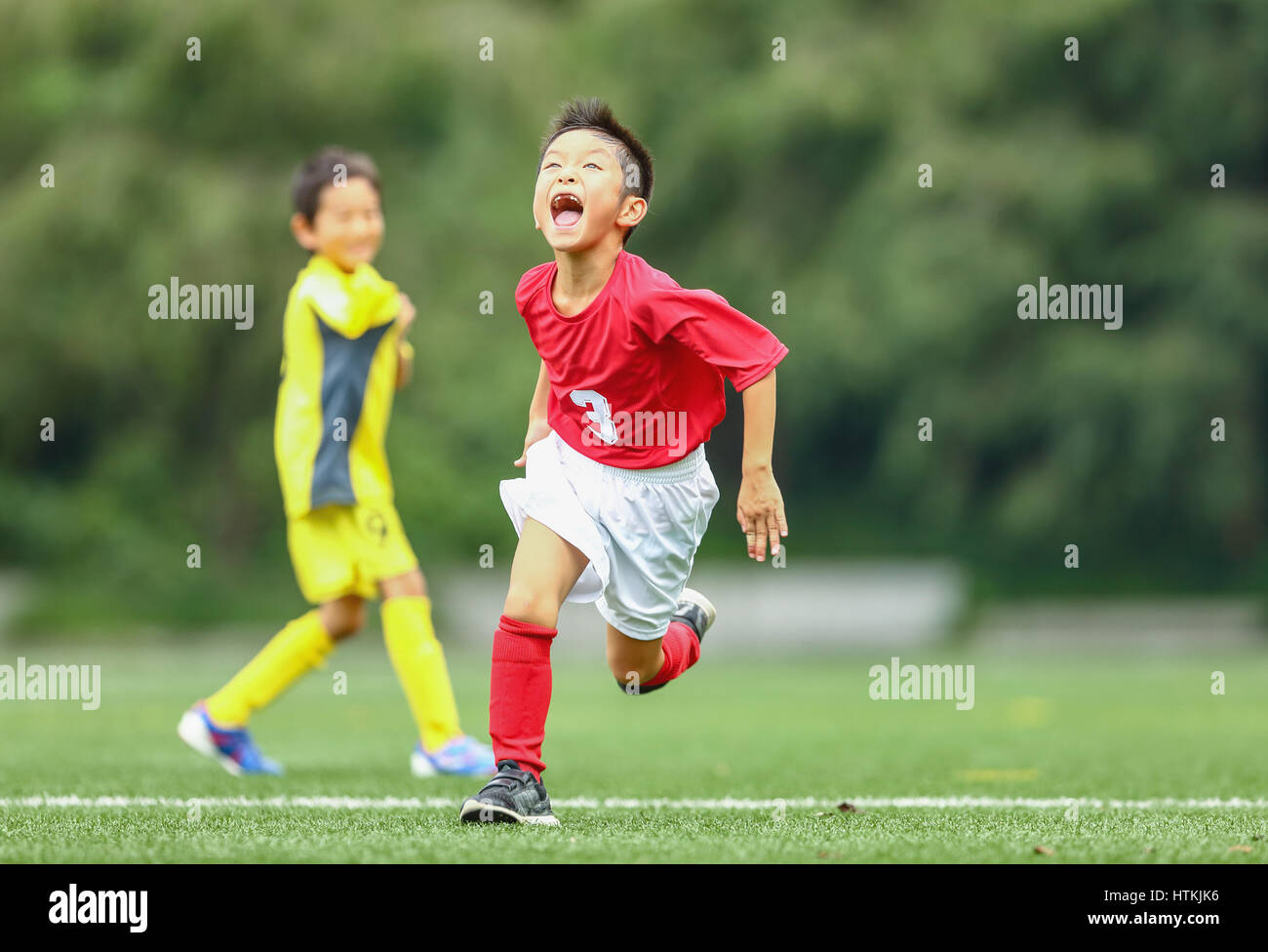 Enfants jouant au football japonais Banque D'Images