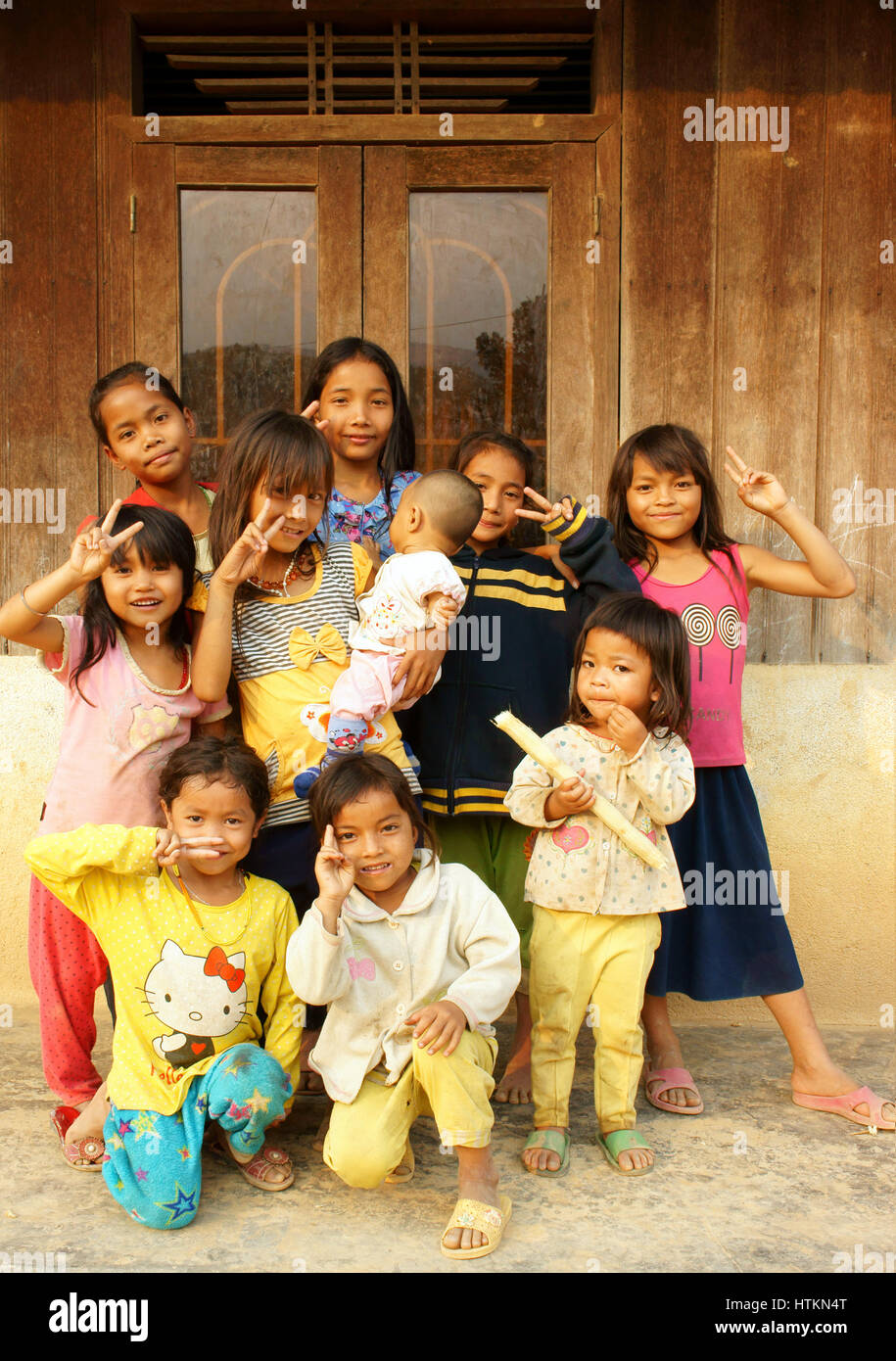 DAKLAK, VIET NAM, les enfants asiatiques stand, posant à la maison en bois de campagne vietnamienne, pauvre enfant, jolie fille heureuse et souriante, Dak Lak, Vietnam Banque D'Images