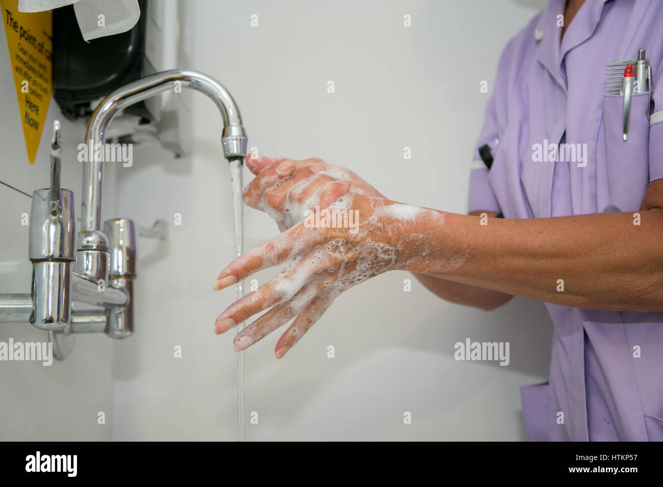 Se laver les mains avec de l'eau savonneuse en milieu clinique Banque D'Images
