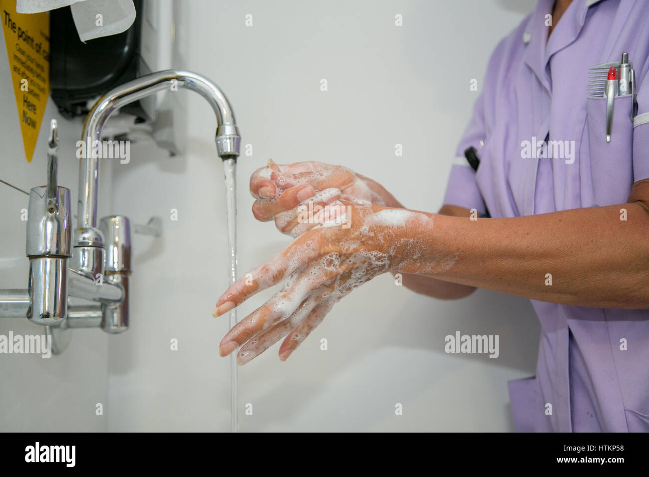 Se laver les mains avec de l'eau savonneuse en milieu clinique Banque D'Images
