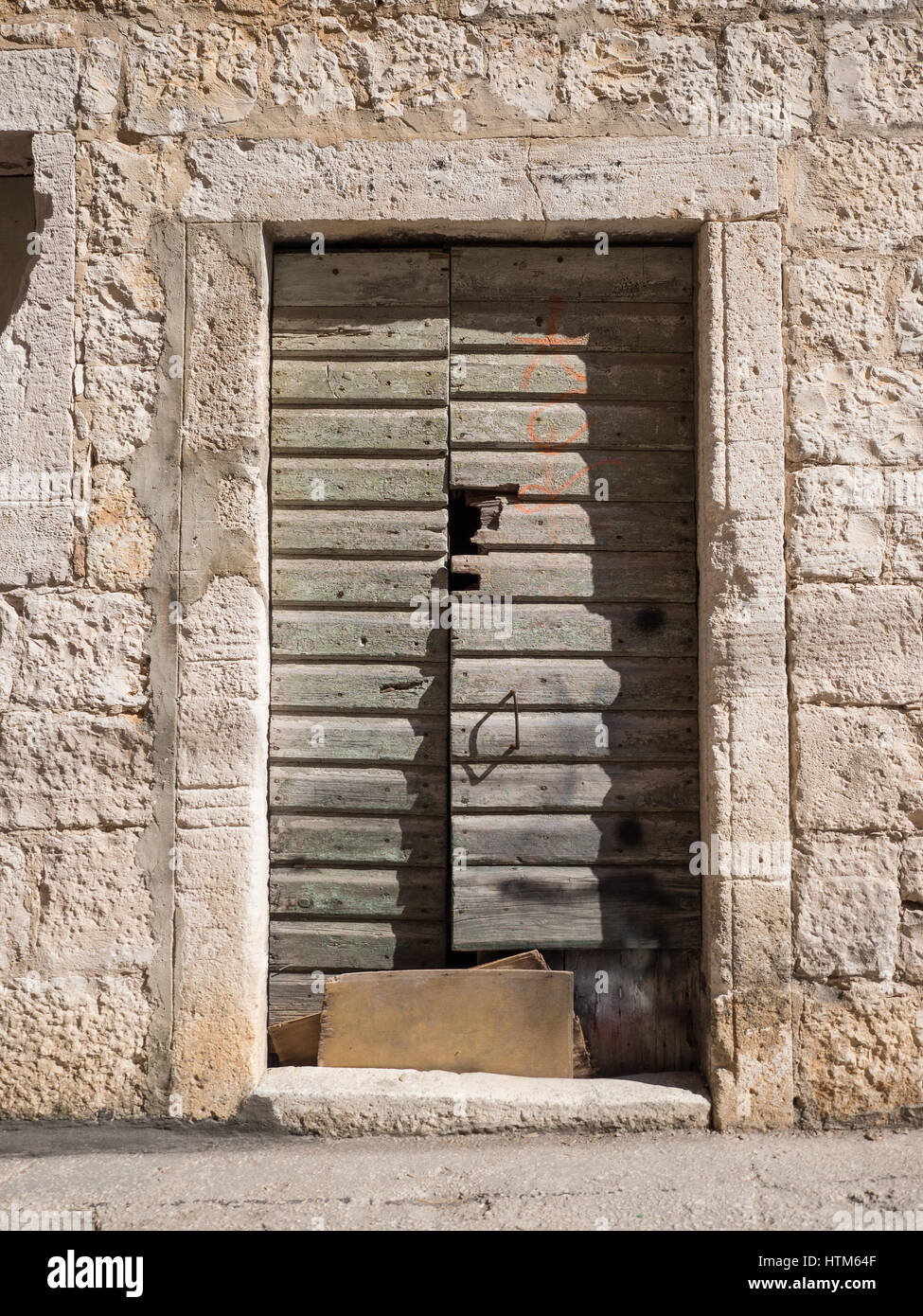 Une antique ancien endommagé la peinture verte de déroulage porte peinte dans le cadre dans un bloc mur de pierre Croatie Banque D'Images